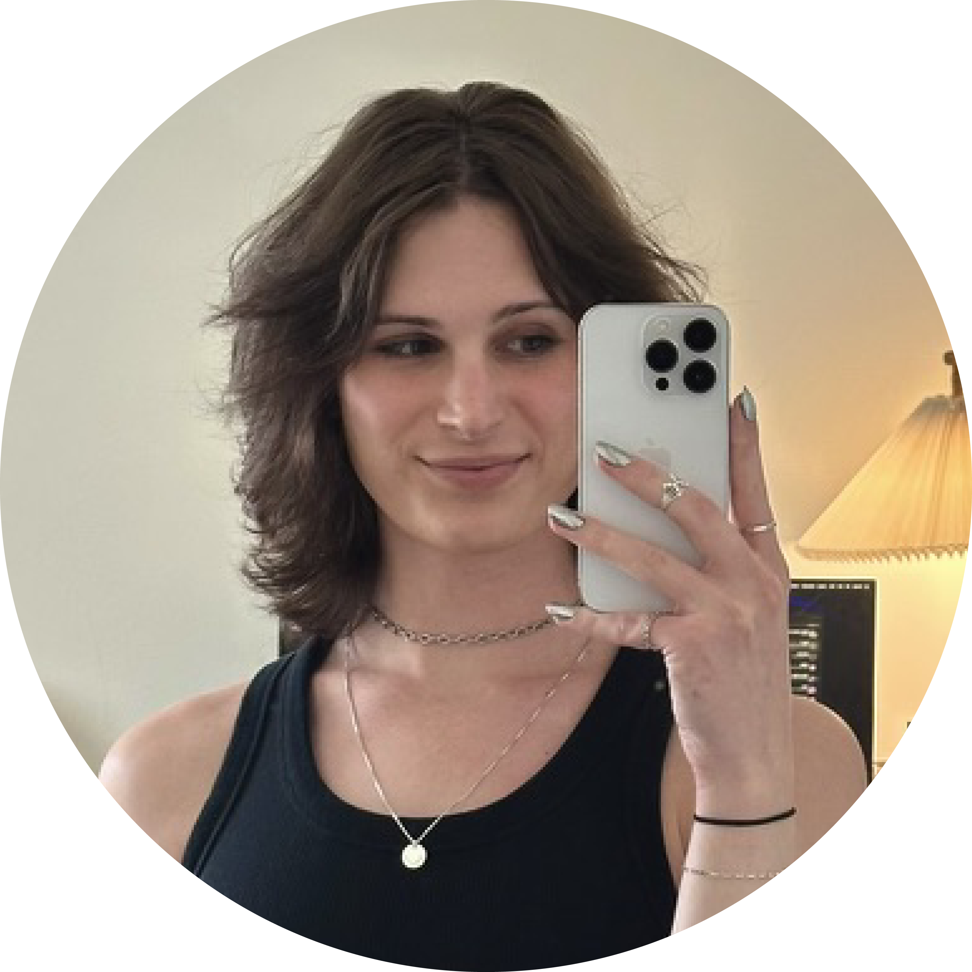 a picture of Zoe. she has brown hair and eyes and is wearing a tanktop with necklaces.
